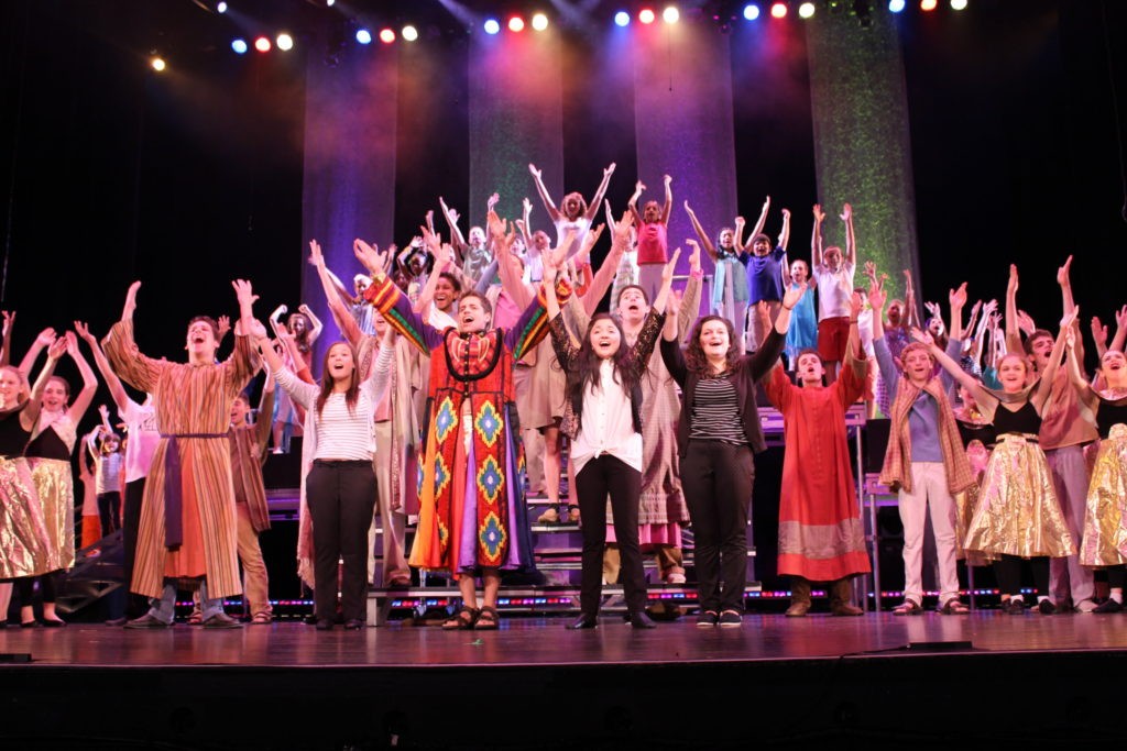 Joseph and the Amazing Technicolor Dreamcoat - group shot with joseph in coat