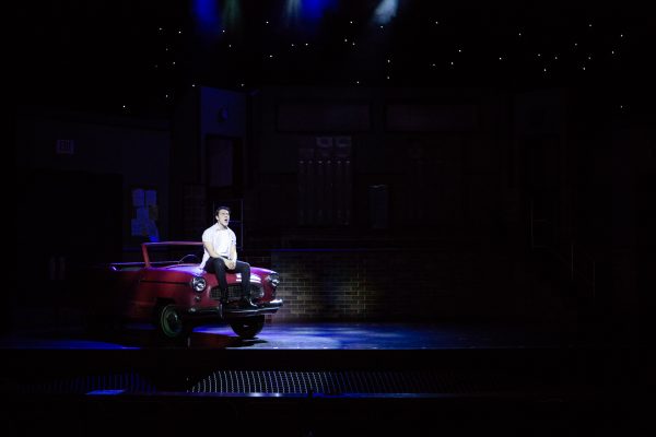 kid sitting on stage on prop car