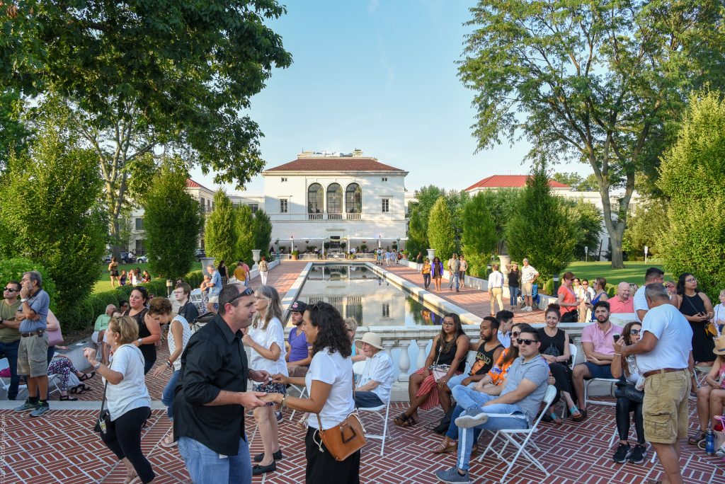 Salsa Under The Stars: large group sitting and dancing at Vail Mansion Plaza