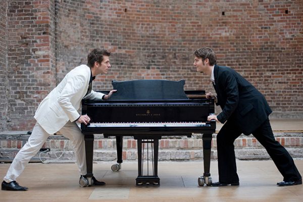 Piano battle, two men in suits pushing piano