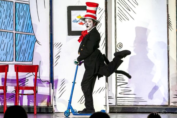 cat in the hat on stage on a scooter