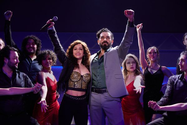 gloria and emilio estefan with arms up