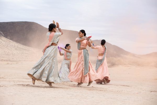 girls dancing in traditional indian garb in desert