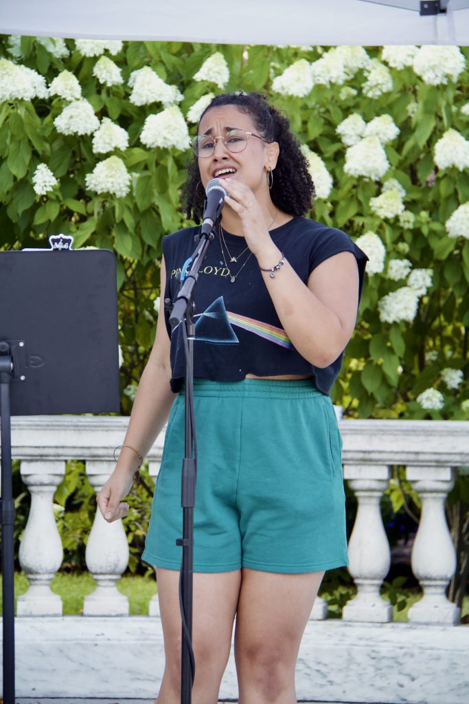 sabrina genesis singing in front of flowers