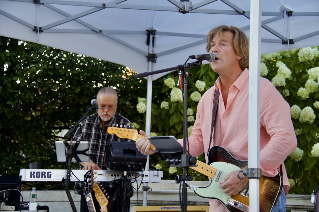 john mcdermott singing and playing guitar with pianist in background